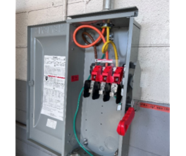 A grey box with red and green wires

Description automatically generated
