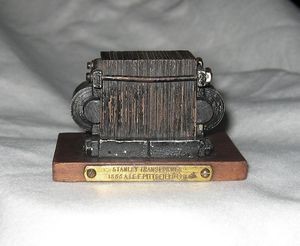 A small wooden object on a white surface

AI-generated content may be incorrect., Picture